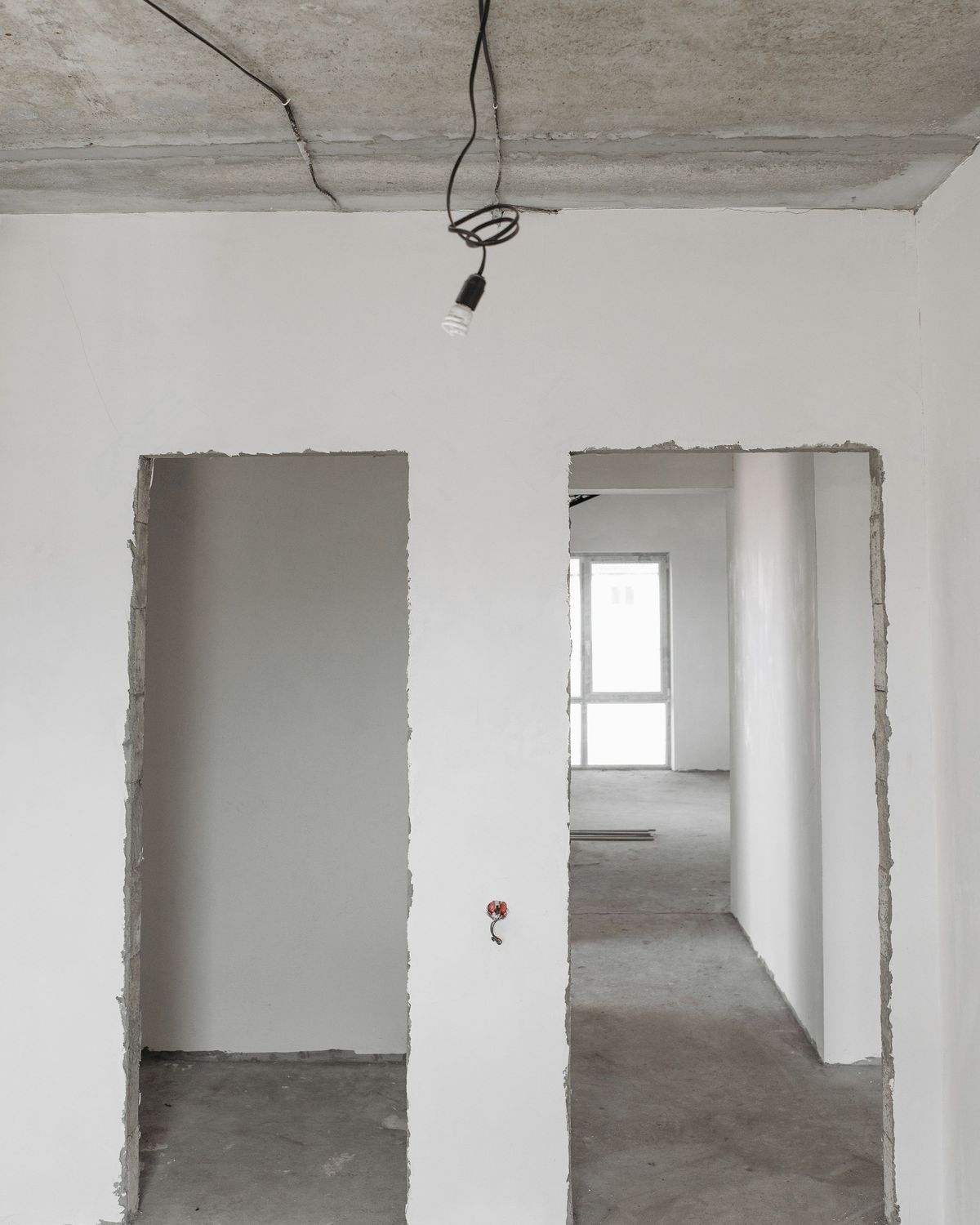 Een kamer met vers bepleisterde witte muren en deuropeningen